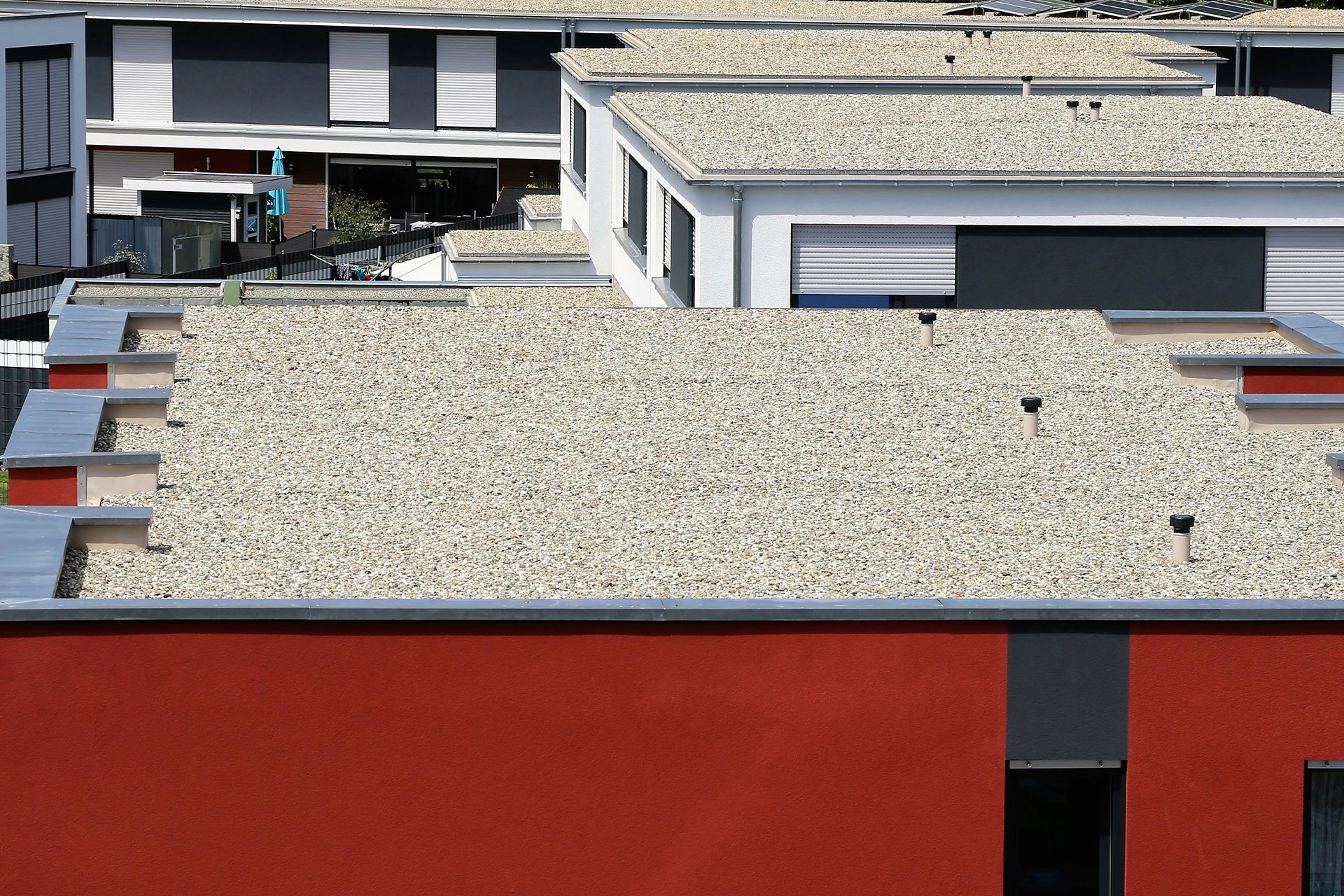 Row of flat roofs with a mineral stone-chip finish
