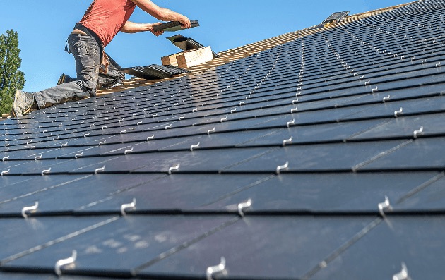 Roofer fixing new slates in neat courses