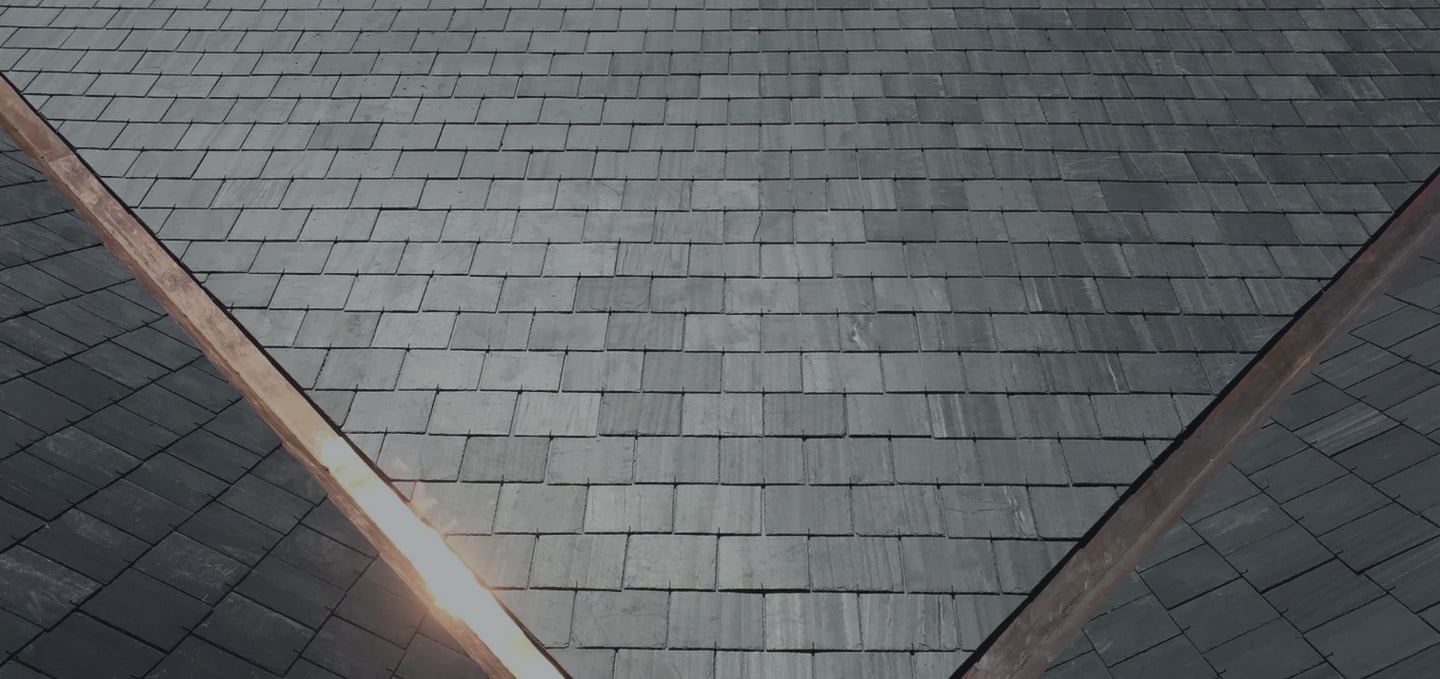 Natural slate roof with copper valleys glowing in low sun